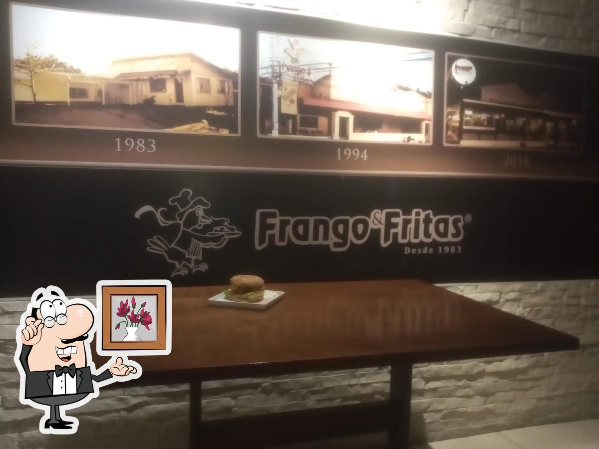 Parede decorada com fotos históricas e a marca Frango & Fritas
